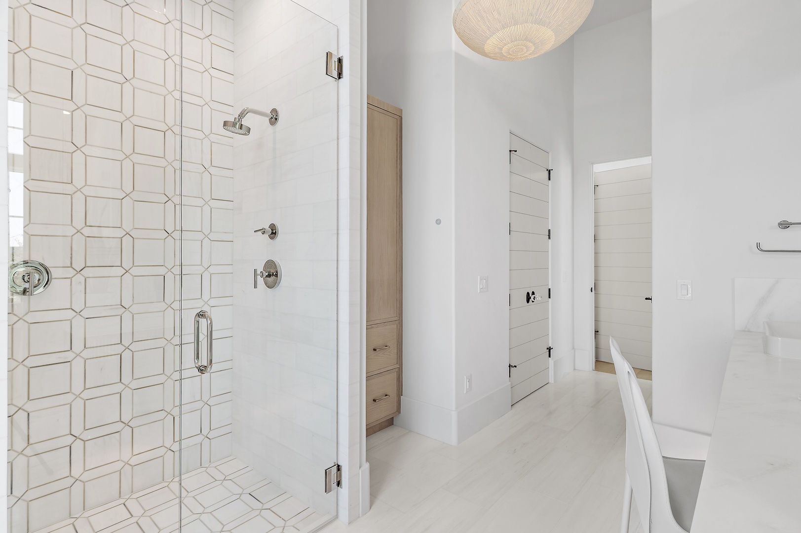 Step into your serene bathroom retreat with stylish geometric tile and gleaming fixtures designed to help you unwind in comfort and style.