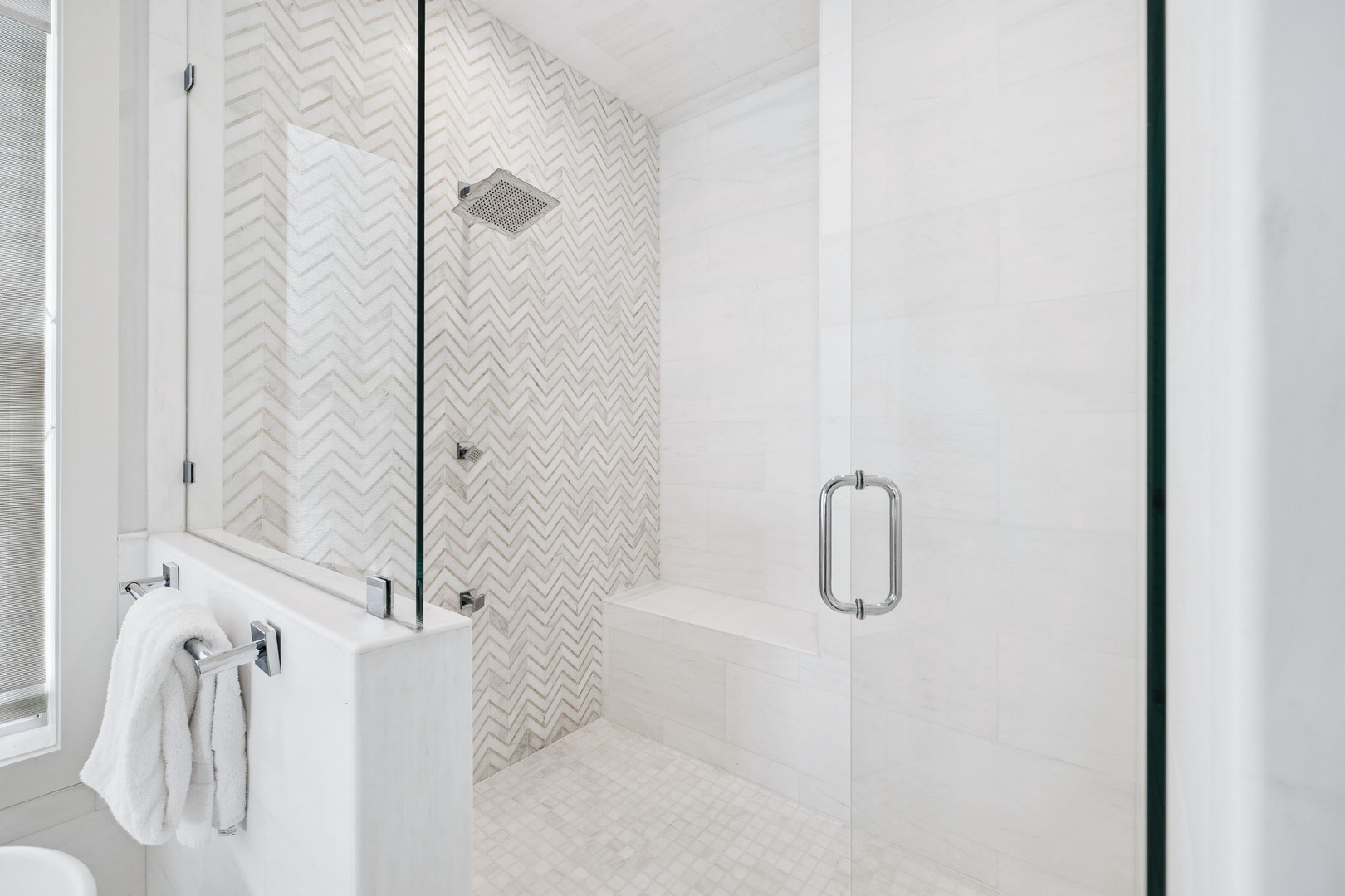 Step into your spa-like bathroom featuring a gorgeous walk-in shower with stunning herringbone tile and sleek glass enclosure.