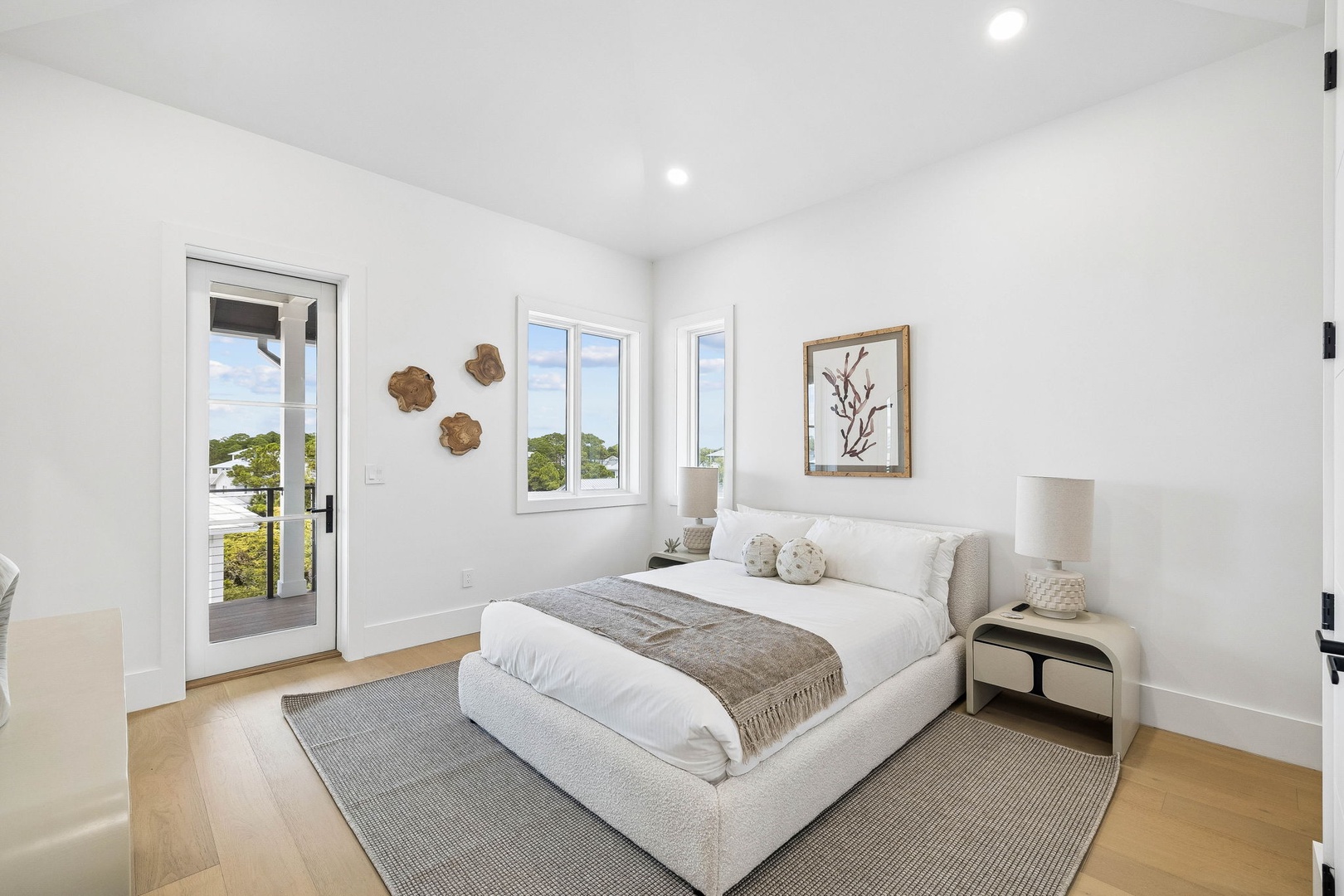 Drift off in your serene, sunlit bedroom with soft coastal touches and a calming palette that invites restful sleep. Natural light pours through your windows, offering peaceful glimpses of lush greenery just outside your door.
