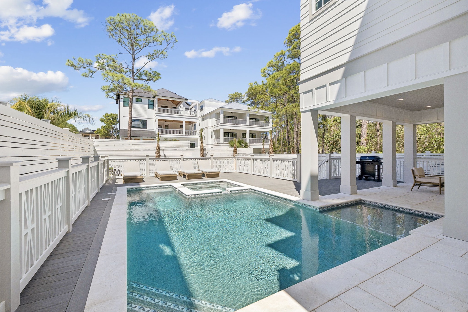 Dive into your private oasis with this stunning pool and spa, surrounded by elegant white architecture and perfect for sunny afternoon swims.