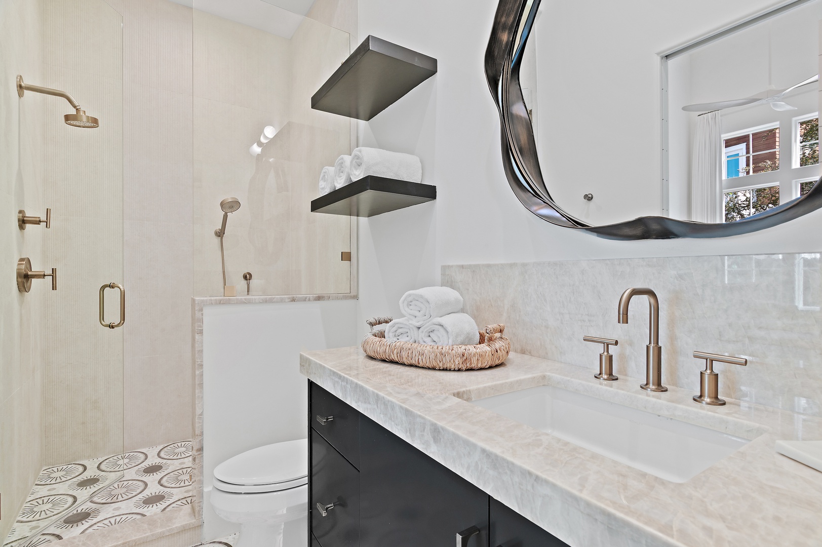 Your private bathroom features elegant marble finishes, a spacious walk-in shower with dual fixtures, and soft towels ready for your arrival—a serene retreat after a day of exploring.