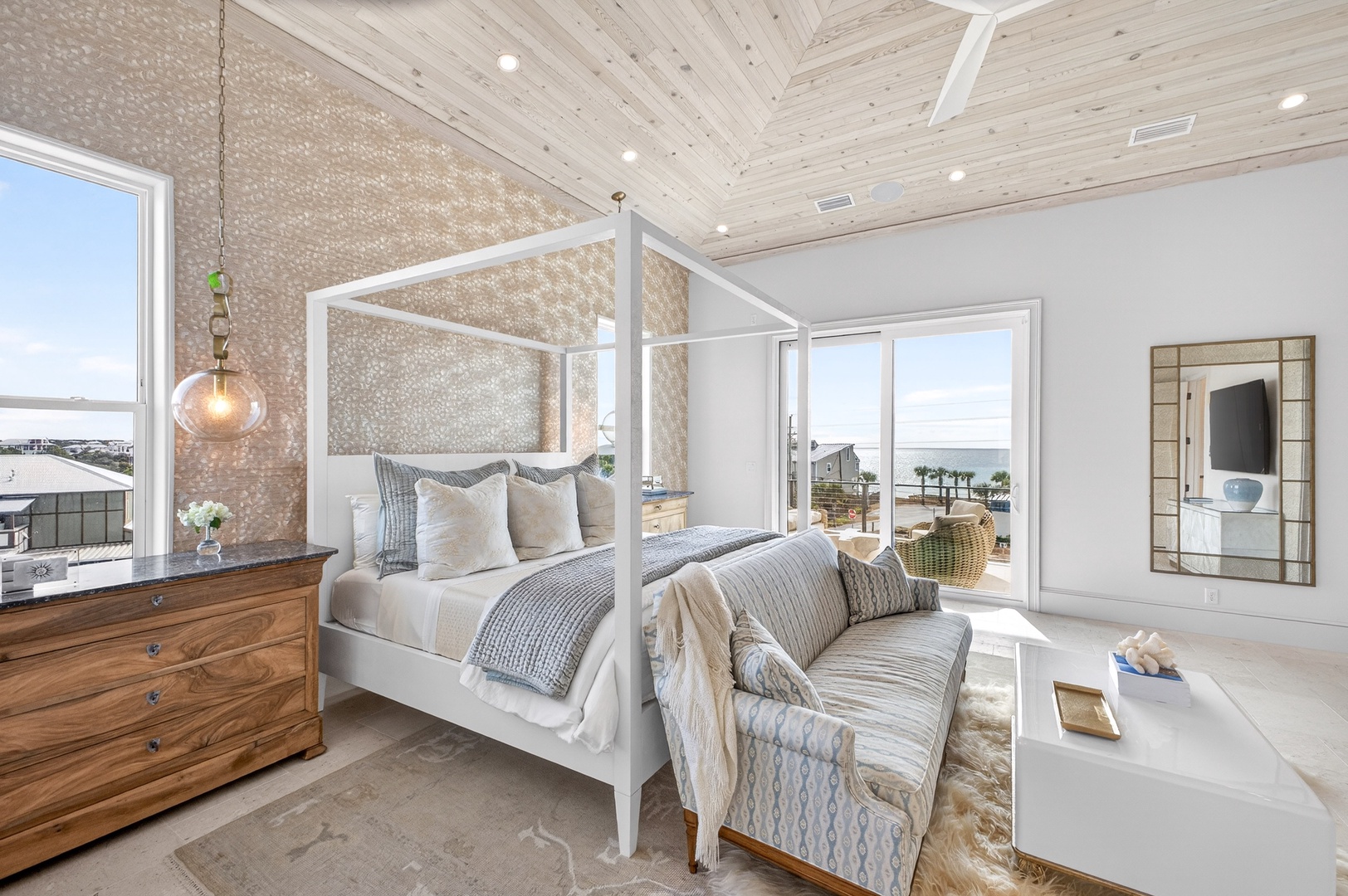 Drift off in your elegant canopy bed while enjoying coastal views through floor-to-ceiling windows in this sophisticated master suite.