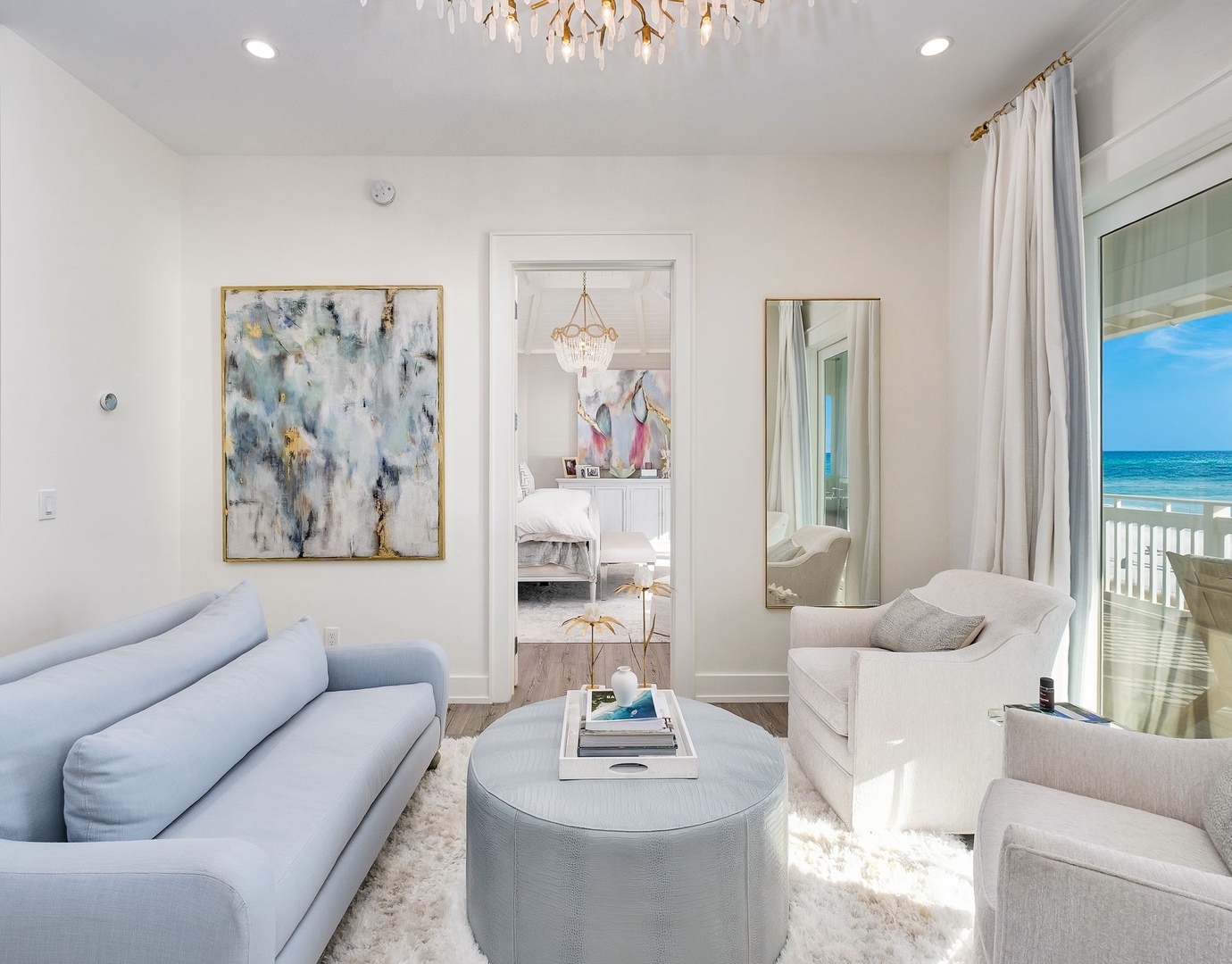 Sink into plush seating as sunlight streams through the glass doors, revealing your private ocean view—a serene retreat where coastal breezes and elegant comfort blend perfectly.