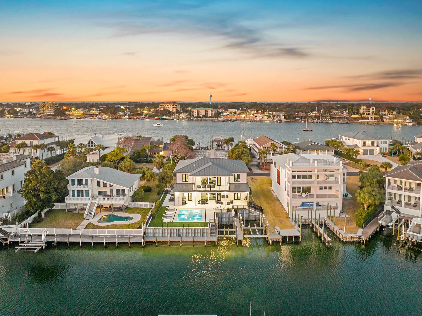 Stunning waterfront property with private pool and dock, perfectly positioned on pristine waters at sunset.