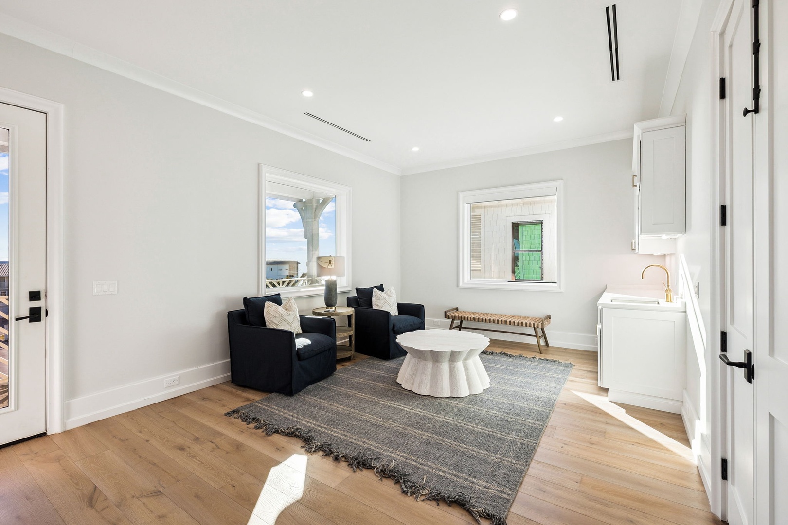 Unwind in your elegant living space with plush navy seating and warm hardwood floors beneath your feet.