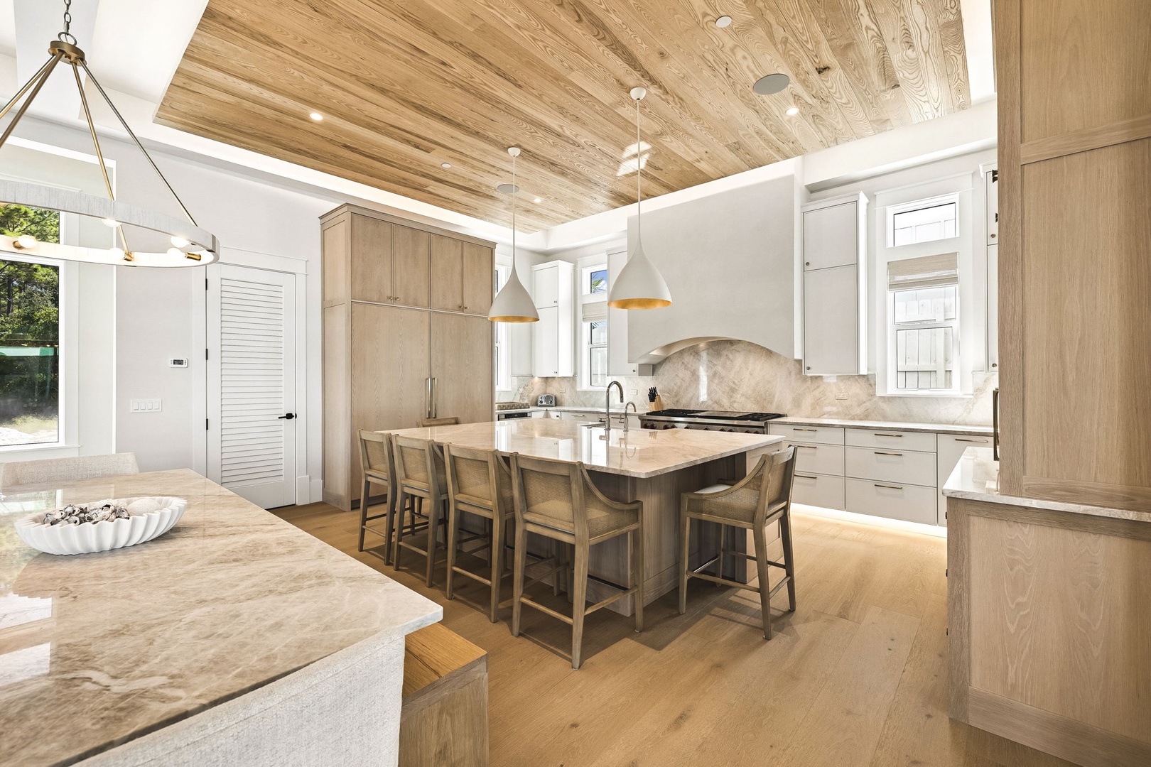 Your gourmet kitchen invites you to gather around the spacious island, where natural wood tones and soft pendant lighting create a warm, welcoming atmosphere for morning coffee or evening meals.