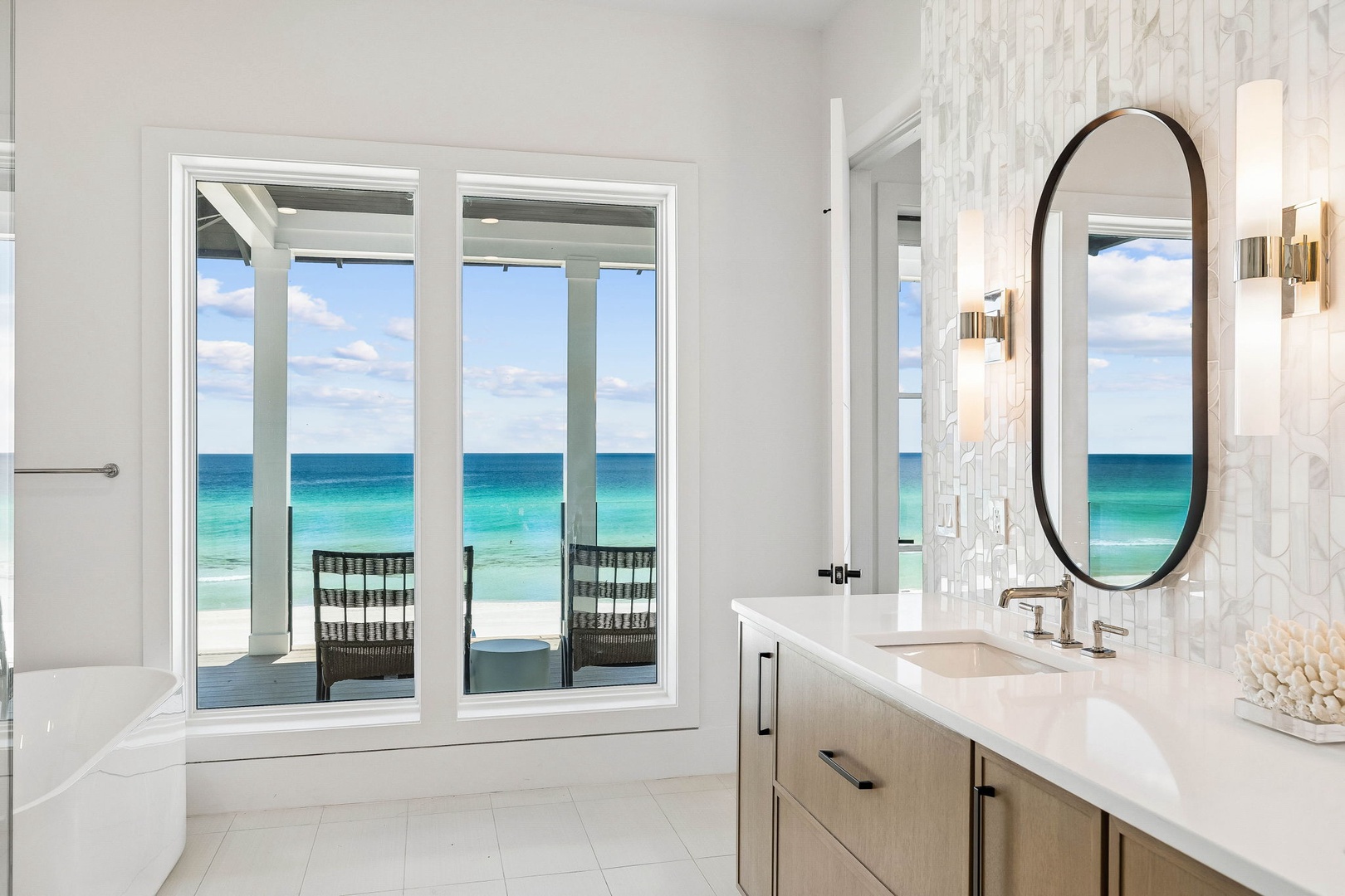 Soak in your private tub while gazing at turquoise waters through floor-to-ceiling windows, letting the ocean become part of your daily ritual in this serene spa-like retreat.