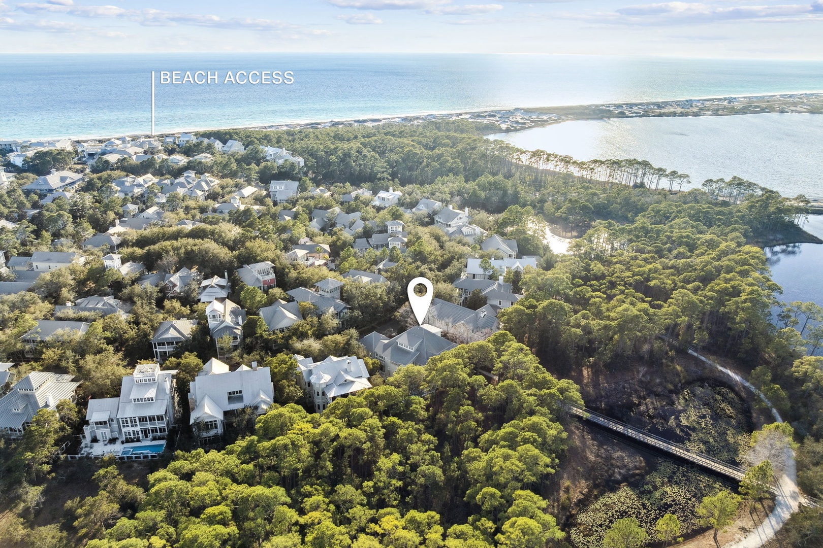 Aerial view of coastal community with beach access and waterfront location surrounded by natural landscape.