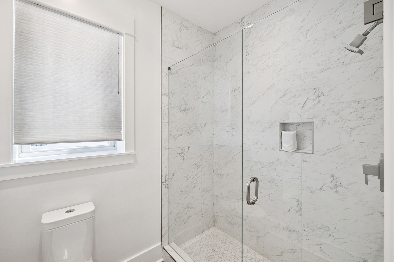 Step into your spa-like marble bathroom with a luxurious walk-in shower featuring elegant glass doors and modern fixtures.