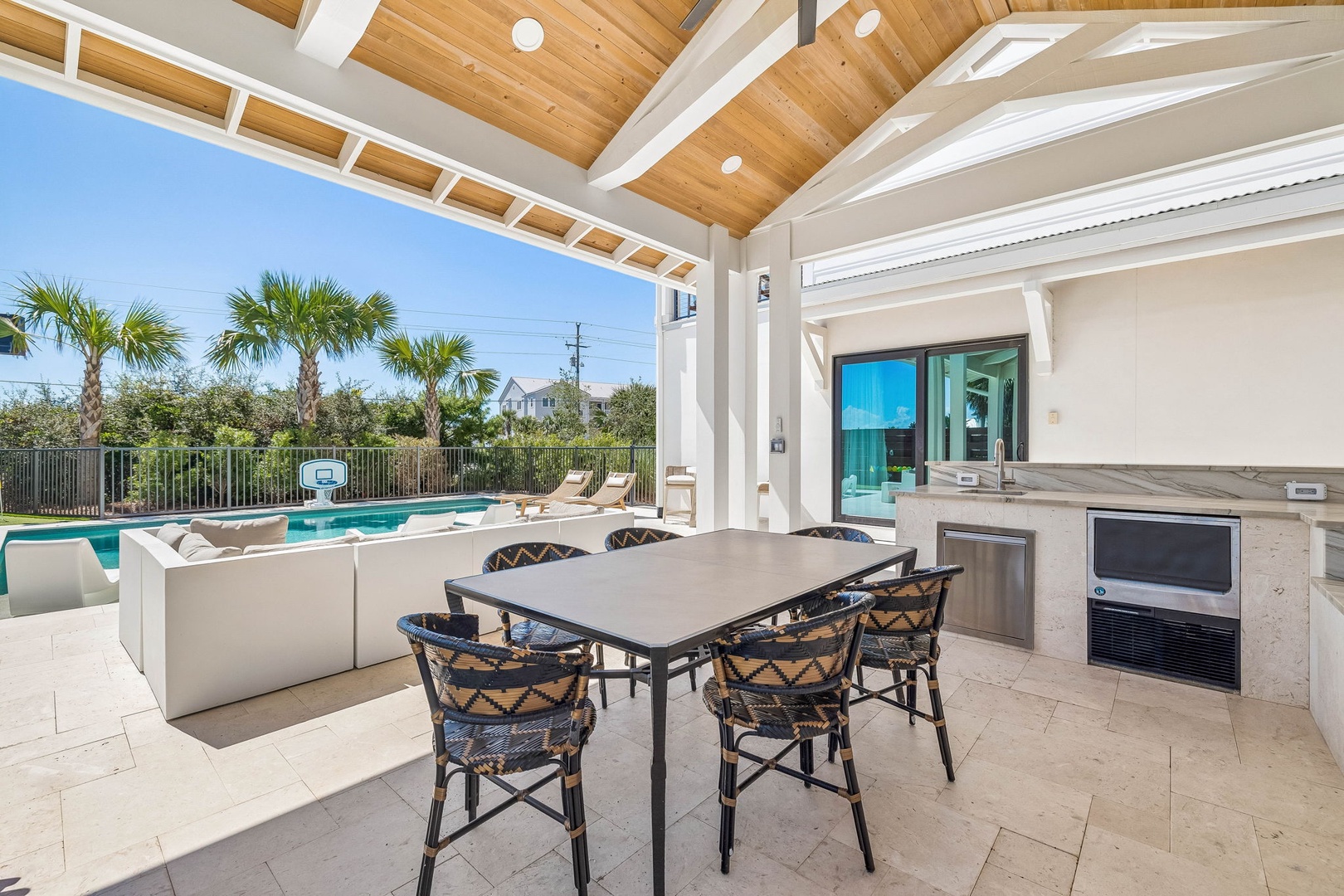 Your private covered patio opens to sparkling pool views and warm sunshine, with a dining table ready for alfresco meals and plush seating where you can unwind in the open air.