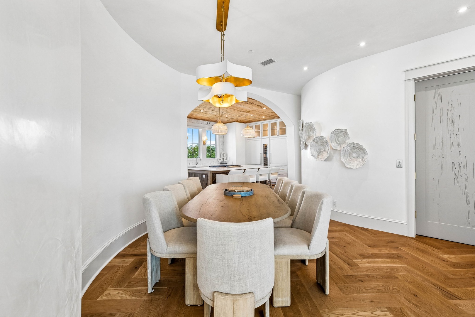 Gather around this elegant dining table, where sunlit meals and evening conversations feel effortlessly special beneath a statement pendant light.