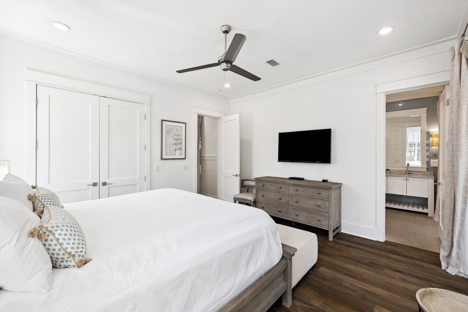 Drift into peaceful sleep in your airy bedroom with crisp linens, modern TV entertainment, and gentle ceiling fan breeze.