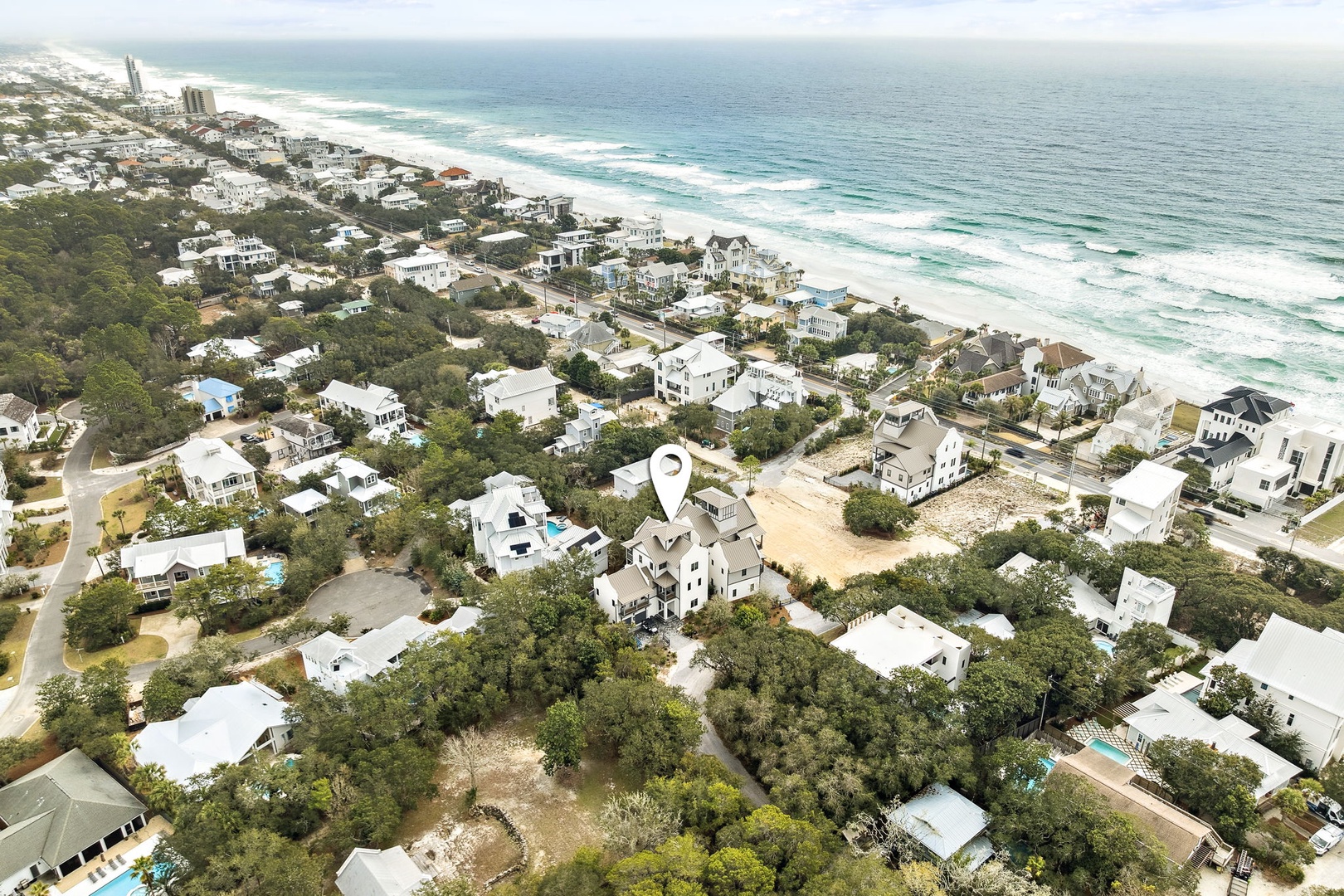 Aerial view of beachfront community showing property location just steps from pristine white sand beaches and turquoise waters.