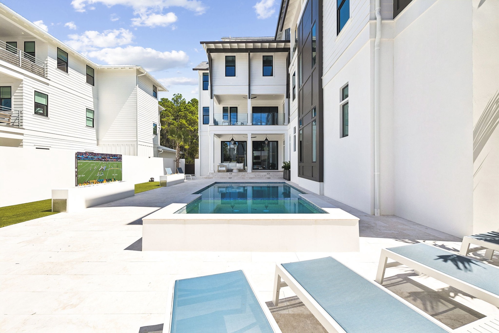 Modern luxury awaits in this pristine outdoor oasis, complete with a sparkling pool and sun loungers perfect for your ultimate relaxation. Sleek architecture frames your private resort-style escape.