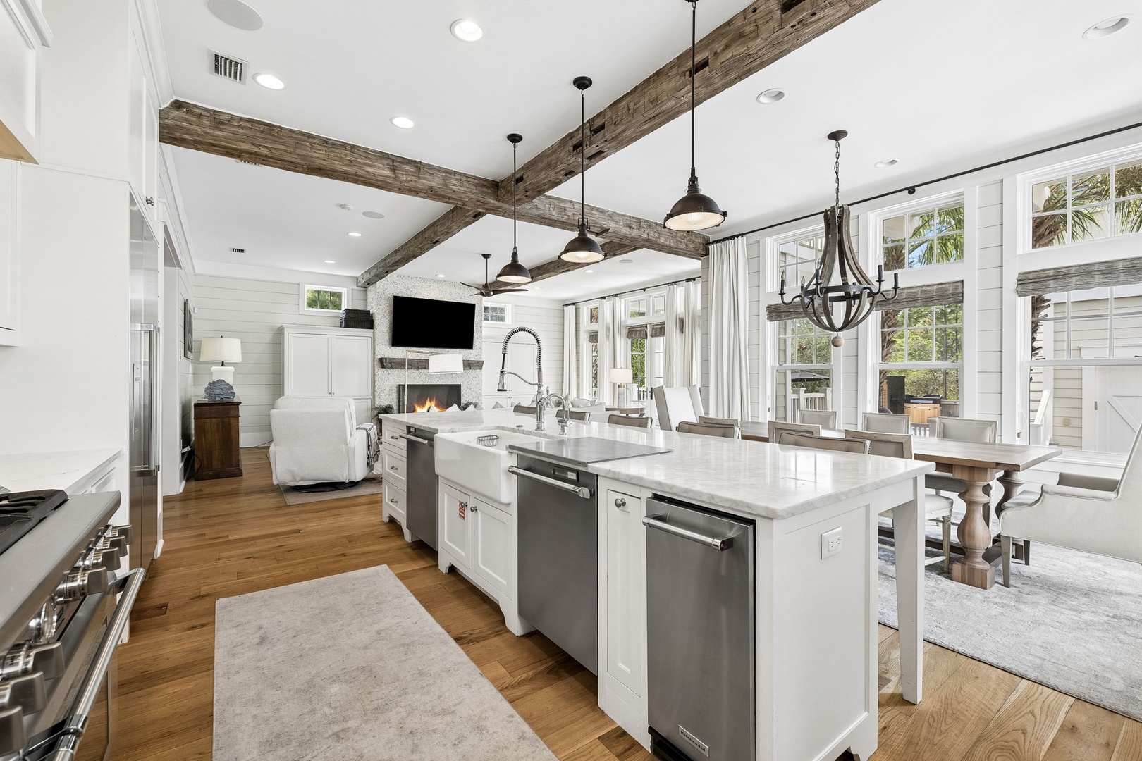 Gather in this stunning open-concept great room where rustic beams and modern luxury meet. Your chef's kitchen features a spacious island, while large windows frame peaceful views and flood the space with natural light.