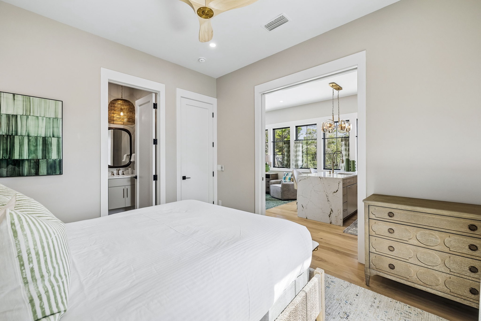 Your serene suite features a plush bed and thoughtfully designed space that flows into a spa-like ensuite. Soft natural light filters through windows into the adjoining living area, creating a peaceful retreat after your day of exploring.