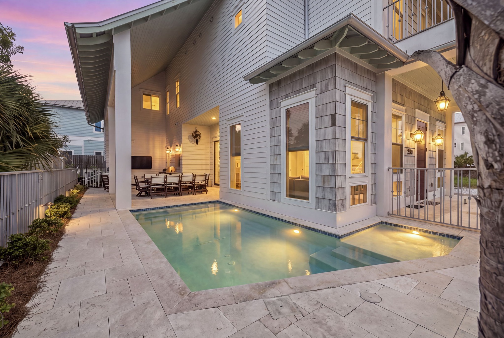 A contemporary coastal home with elegant architecture, private pool, and covered patio captured during golden hour twilight.