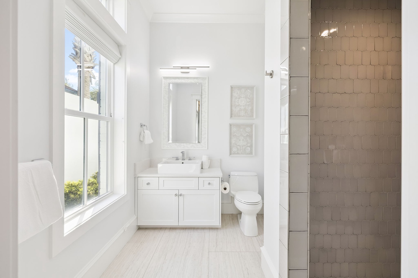 Step into your bright, modern bathroom where natural light streams through the window and elegant hexagonal tiles add sophisticated charm to your shower experience.