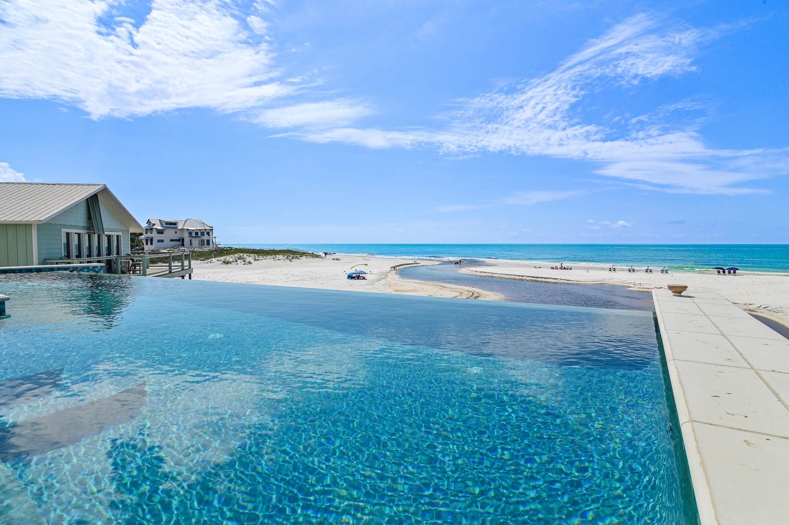 Step outside to your stunning infinity pool where turquoise waters mirror the Caribbean sky and white sand beaches stretch endlessly before you—pure coastal paradise at your doorstep.
