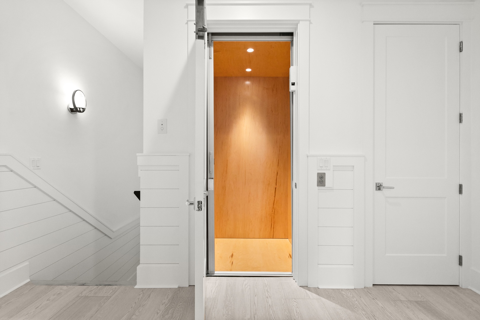 A bright elevator with warm wood tones stands ready to carry you effortlessly between floors, blending modern convenience with coastal elegance.