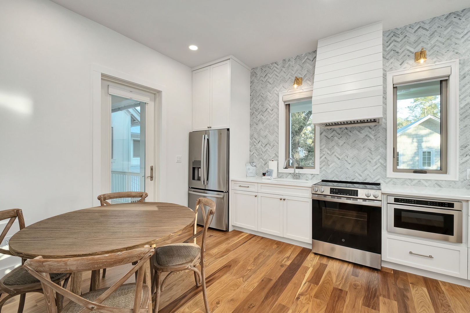 Cook effortlessly in your modern kitchen featuring premium appliances, elegant marble backsplash, and warm wood floors perfect for memorable meals.