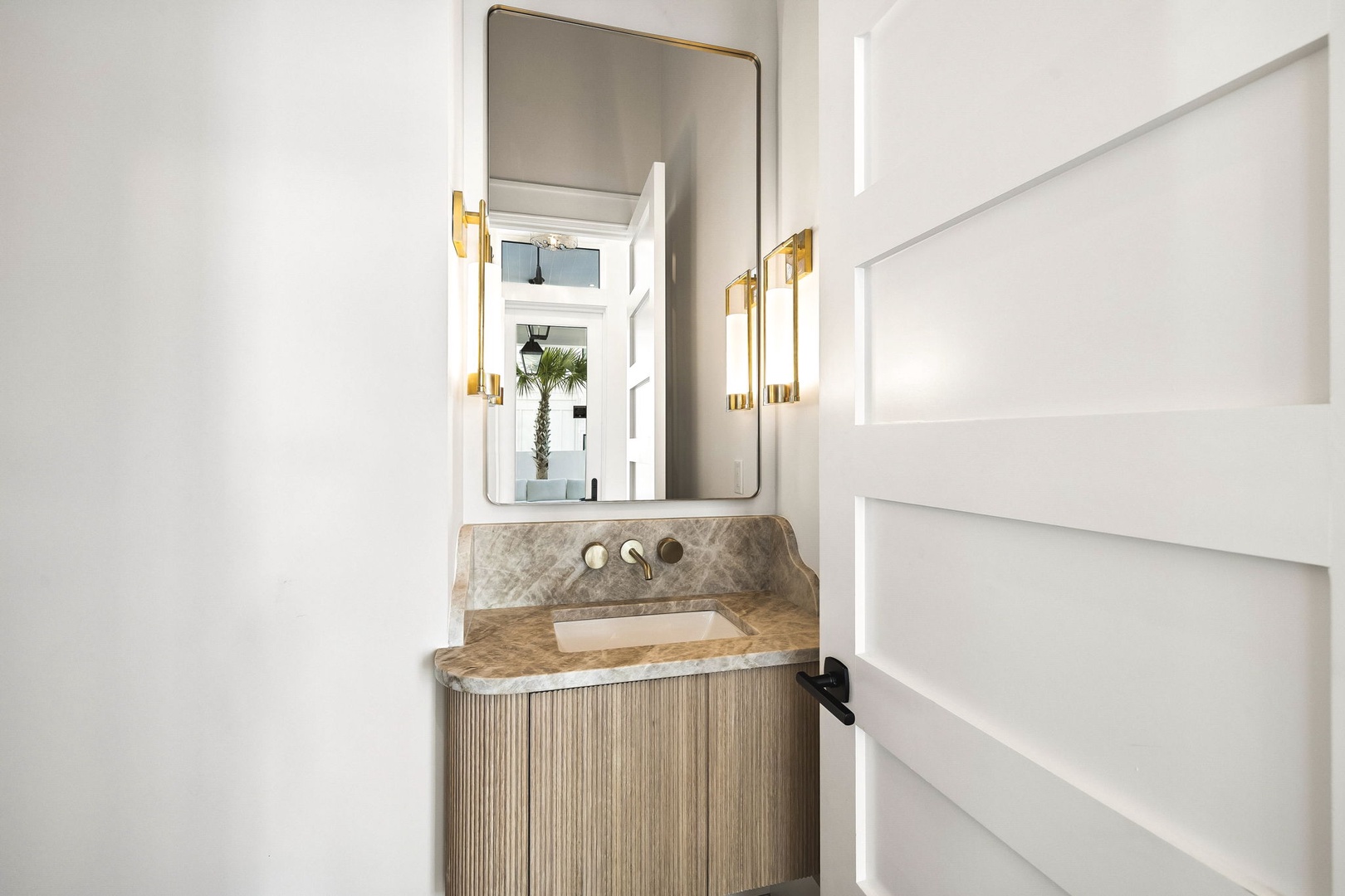 Step into elegance with this beautifully designed powder room featuring a stunning marble vanity and chic gold accents that catch the light just right.