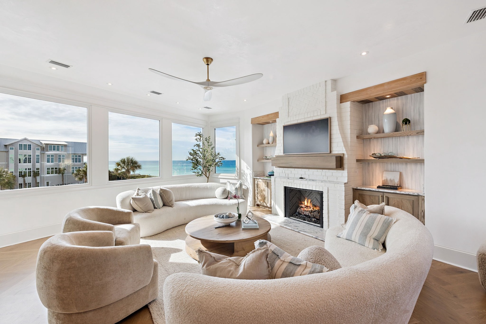 Curl up in this serene living room with coastal views, a cozy fireplace, and plush seating perfect for unwinding after your beach adventures.