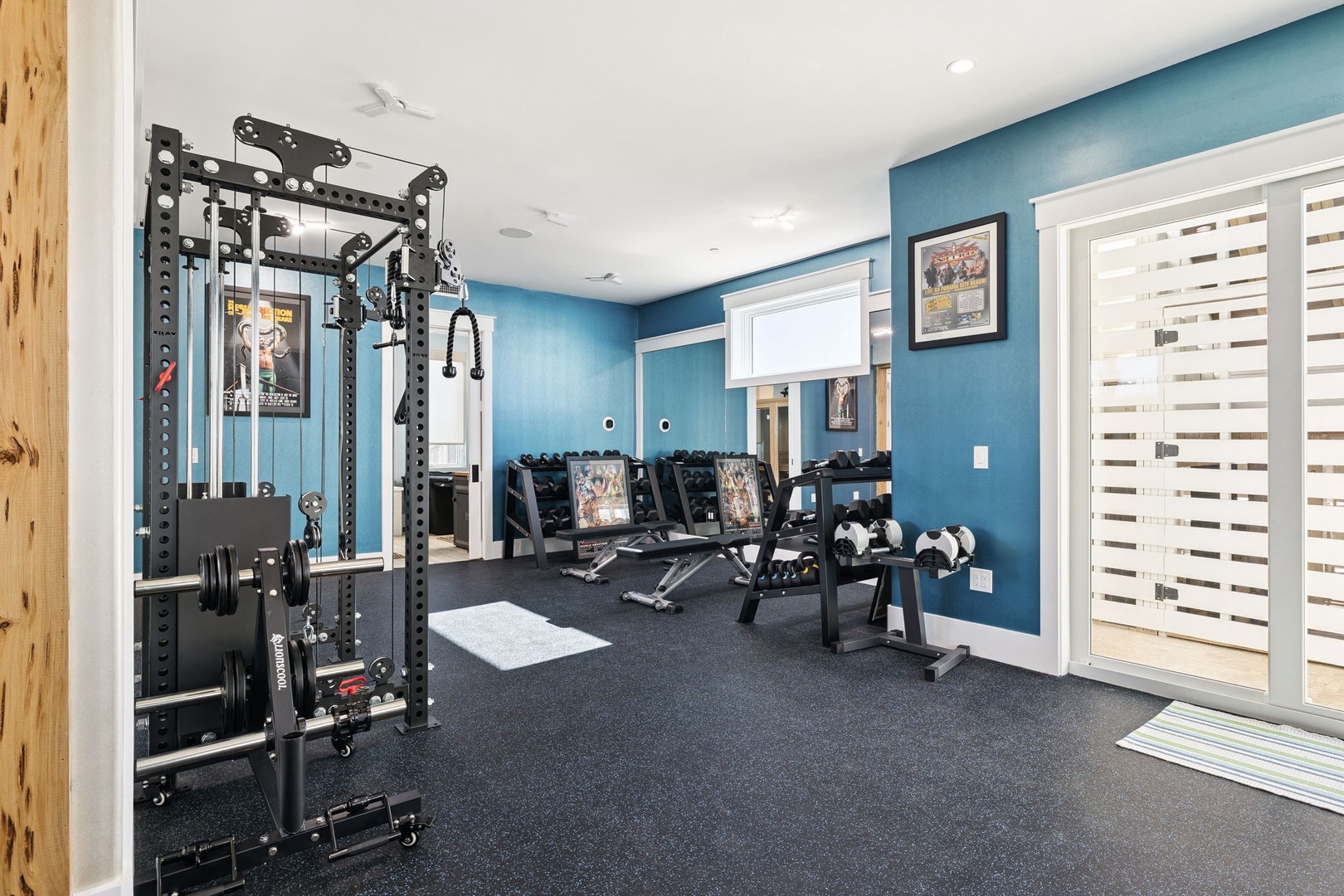 Your private fitness sanctuary features professional equipment and calming blue walls, perfect for maintaining your workout routine.
