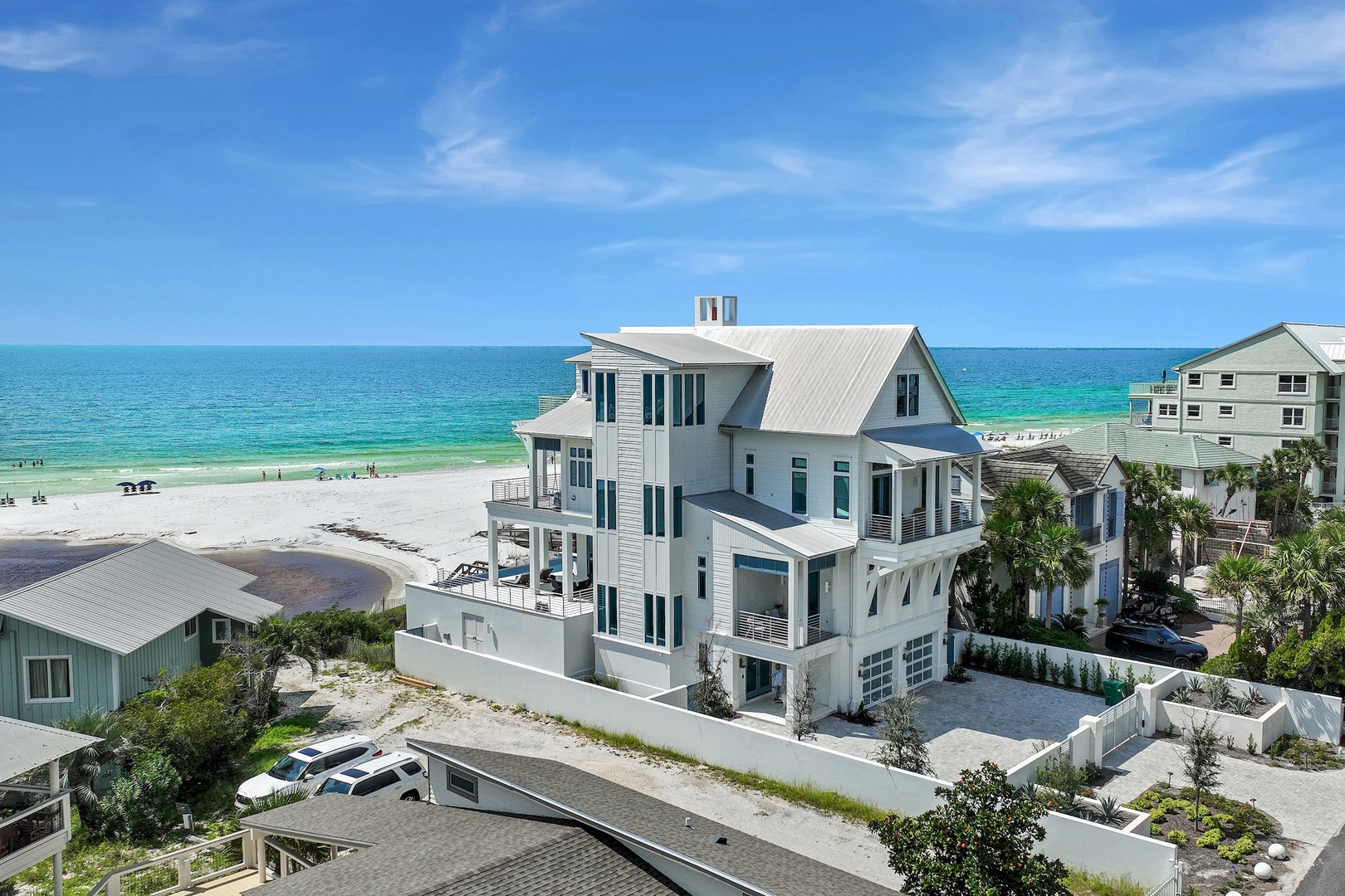 A stunning beachfront property showcasing elegant coastal architecture, positioned steps from pristine white sand and turquoise Gulf waters.