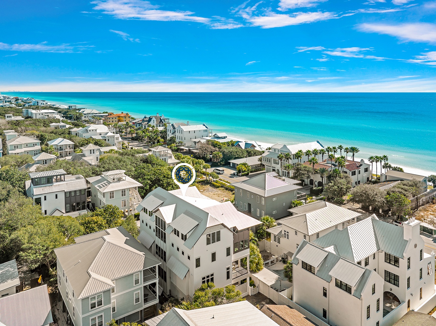 Aerial view of beachfront community with turquoise waters and pristine sandy coastline featuring vacation rental properties.