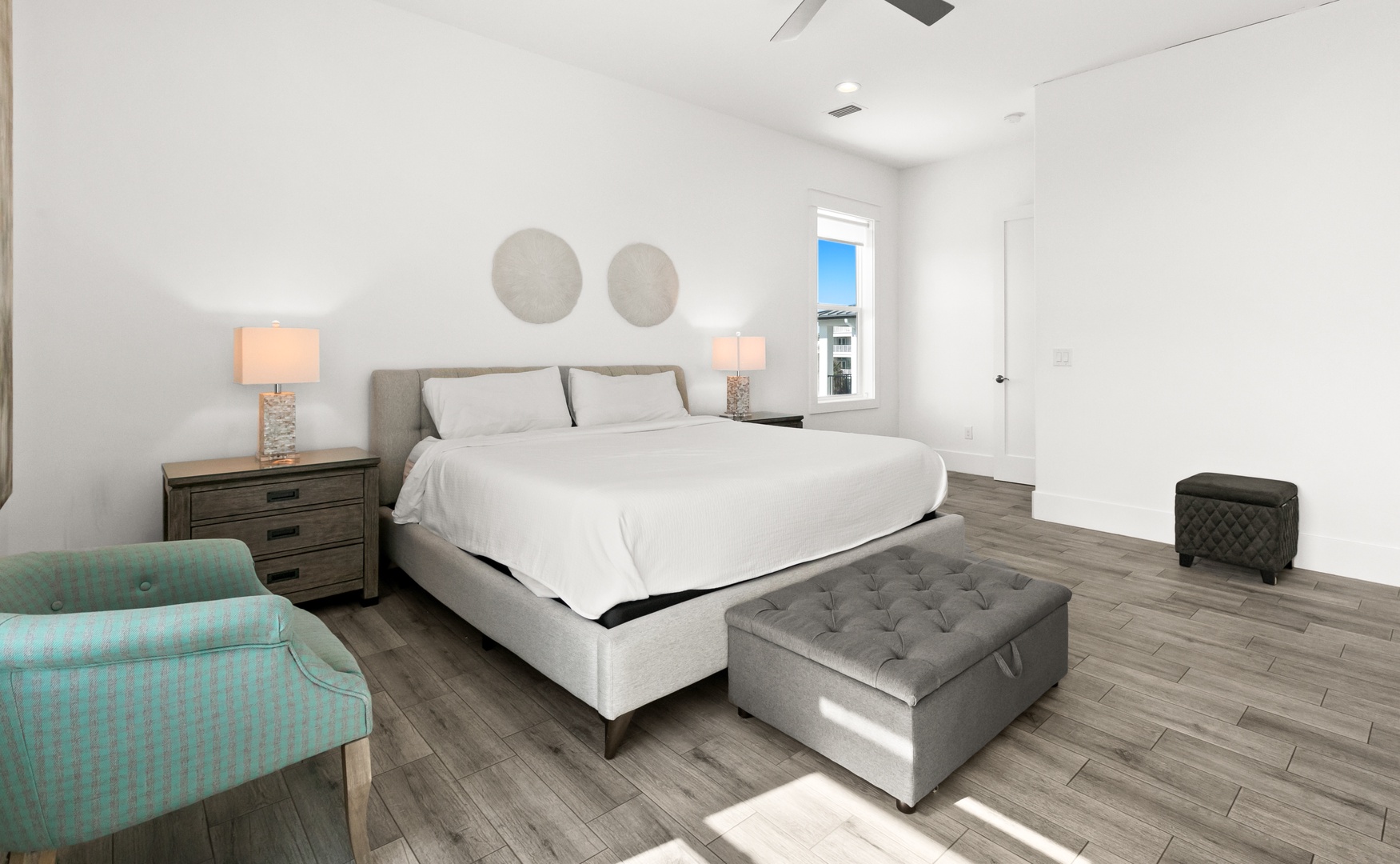Sink into crisp white linens on your plush king bed, with soft lamplight and coastal details creating a serene escape. Your peaceful bedroom retreat awaits after each day's adventure.