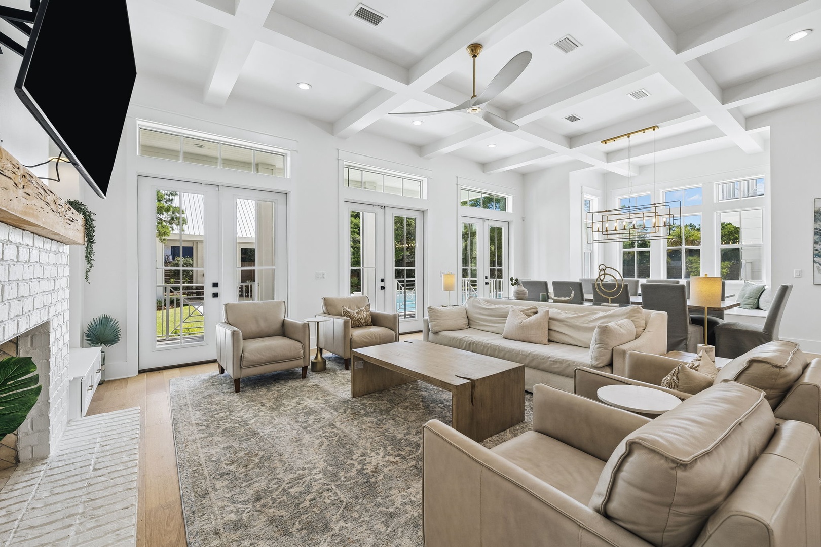 Sink into plush sofas in your bright, airy living room, where towering coffered ceilings and elegant chandeliers frame a space designed for relaxation and connection.