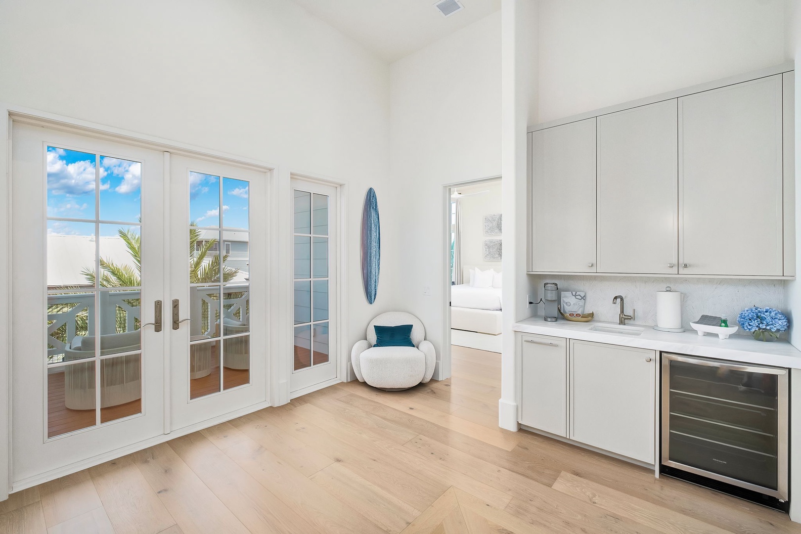 Step into your airy, sun-filled retreat with coastal charm at every turn. French doors open to your private balcony with palm-lined views, while sleek cabinetry and countertops await your morning coffee ritual.