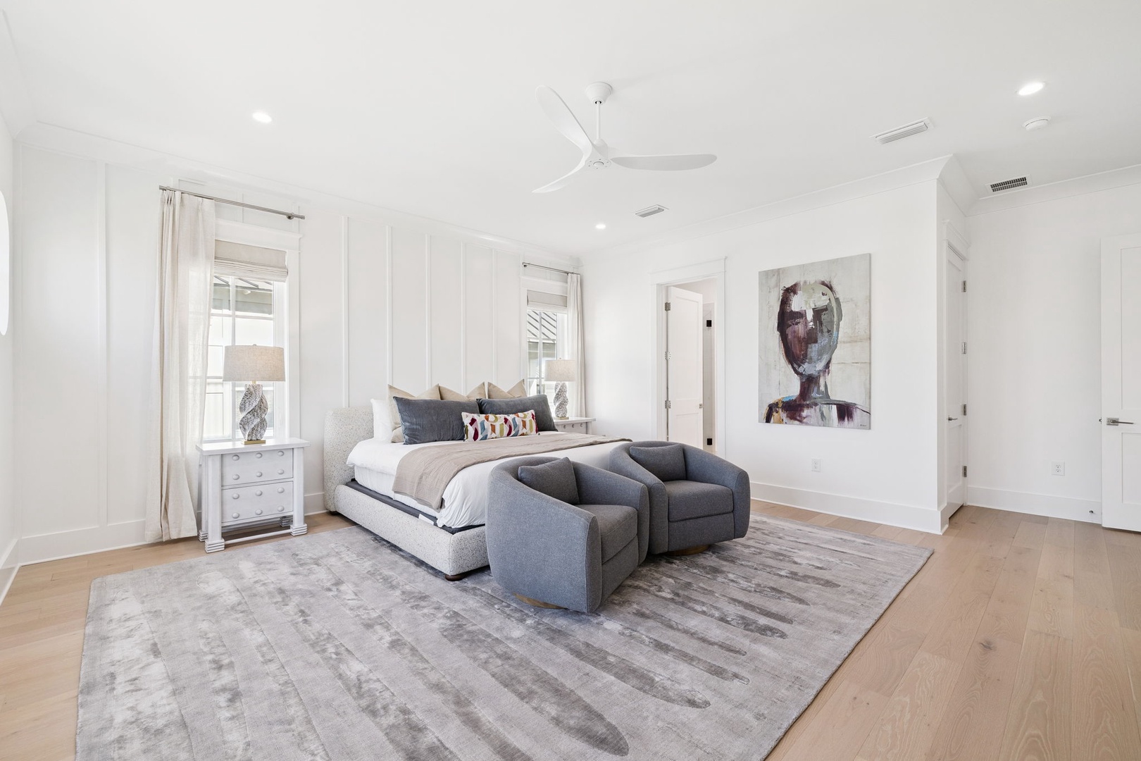 Unwind in your elegant master suite with plush bedding, cozy seating nook, and contemporary art creating the perfect sanctuary.