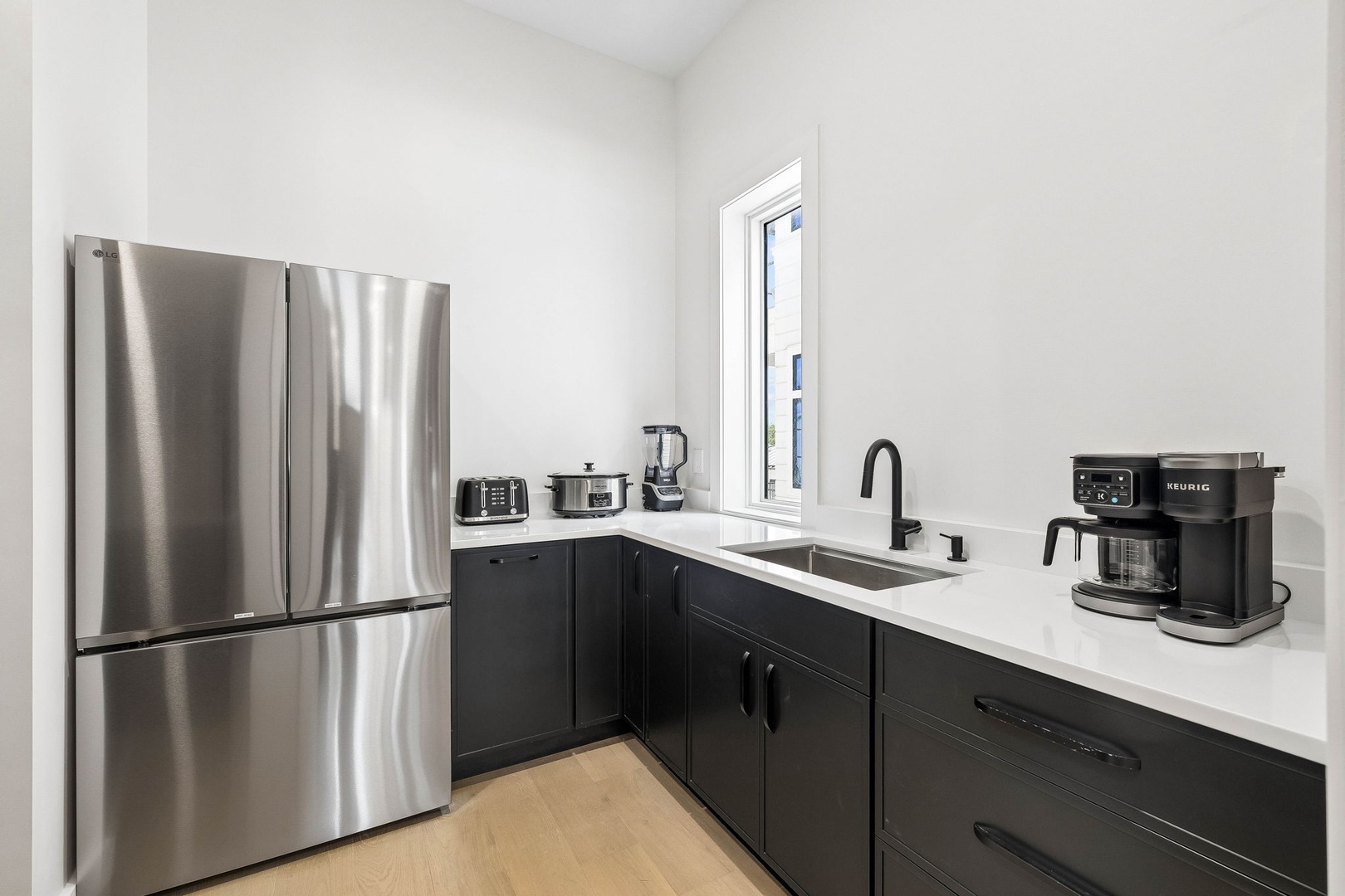 Step into your sleek, modern kitchen outfitted with stainless steel appliances, crisp white countertops, and dark cabinetry for a refined, contemporary feel. You'll love how effortlessly functional and stylish your cooking space is.
