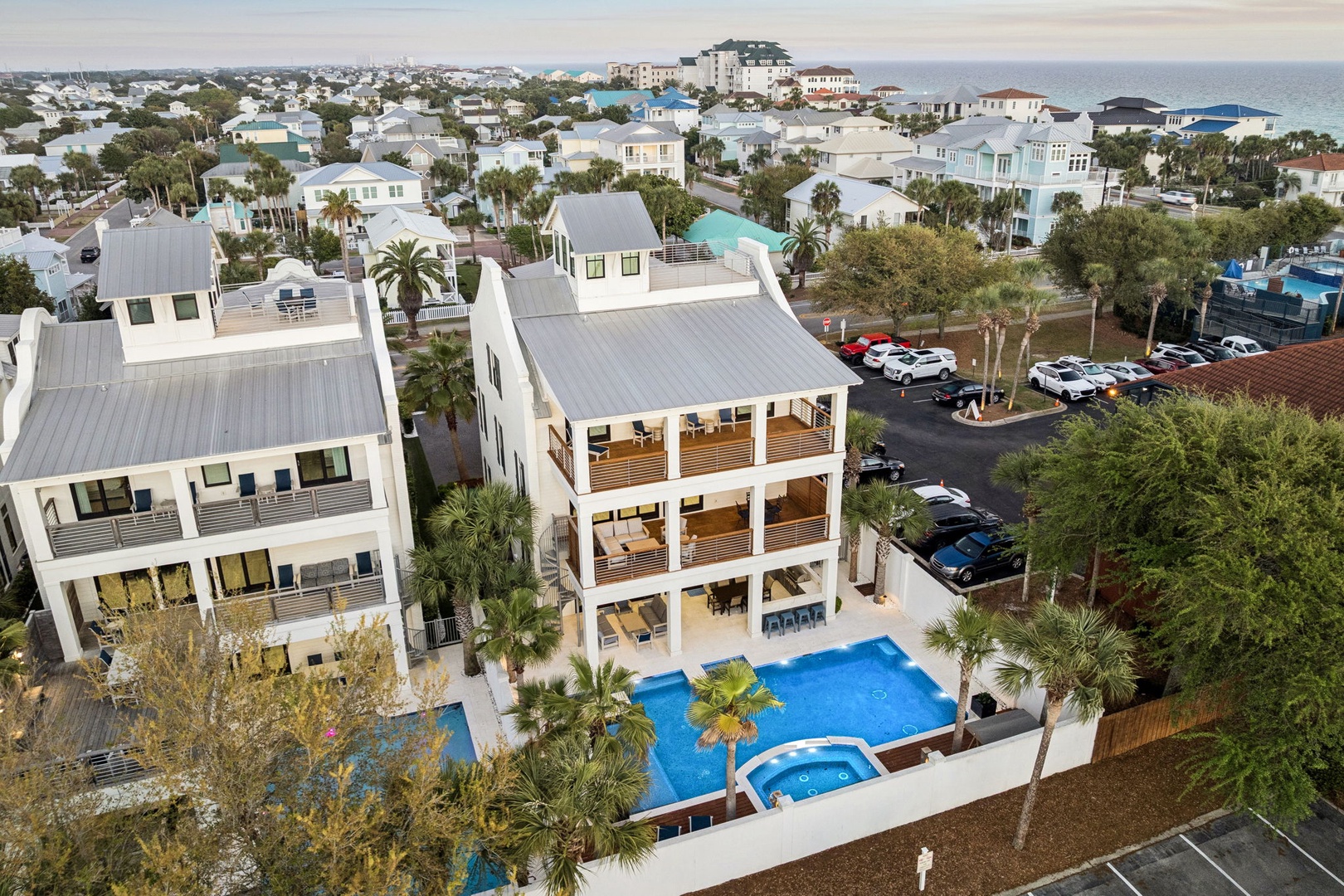 Stunning aerial view of modern vacation rental with pool, surrounded by coastal community near pristine beaches.
