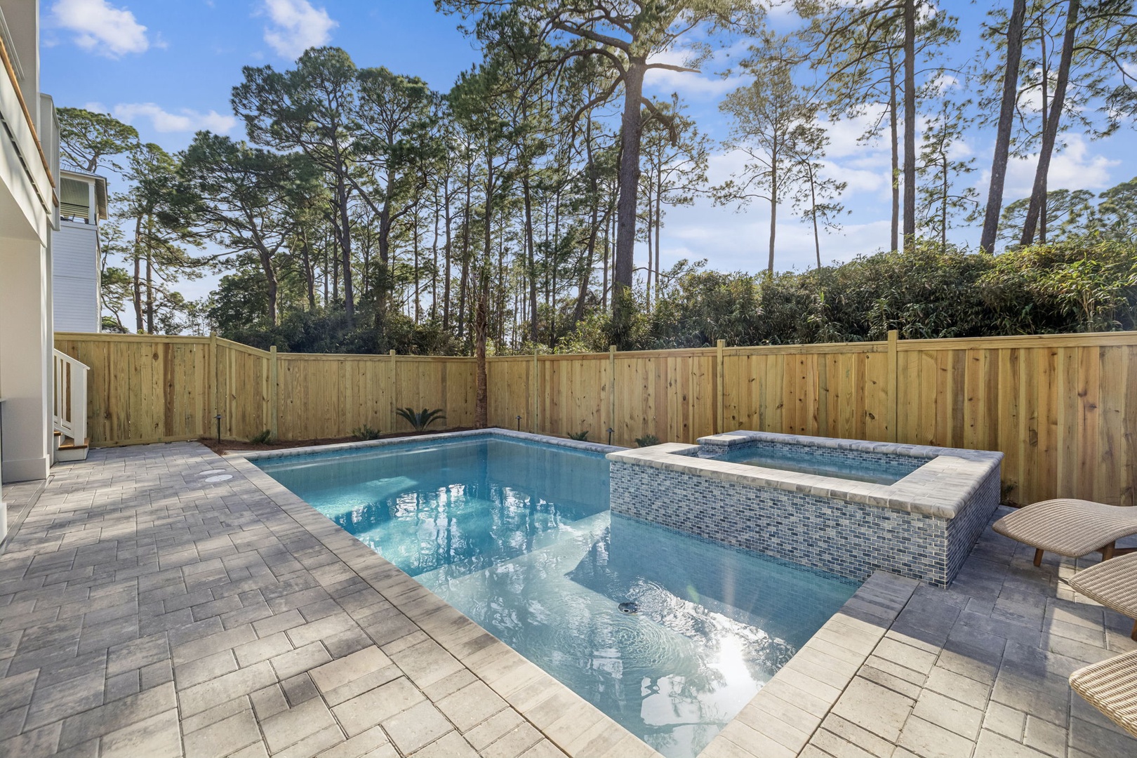 Dive into your private oasis featuring a sparkling pool and elevated spa, surrounded by peaceful wooded views for ultimate relaxation.