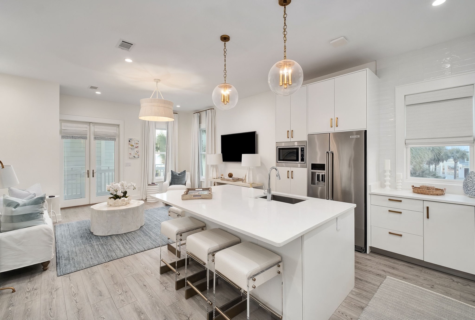 Imagine yourself in this bright, open-concept space where crisp white tones meet coastal charm. The kitchen island invites you to gather, while natural light pours through the windows, making your stay feel airy and relaxed.
