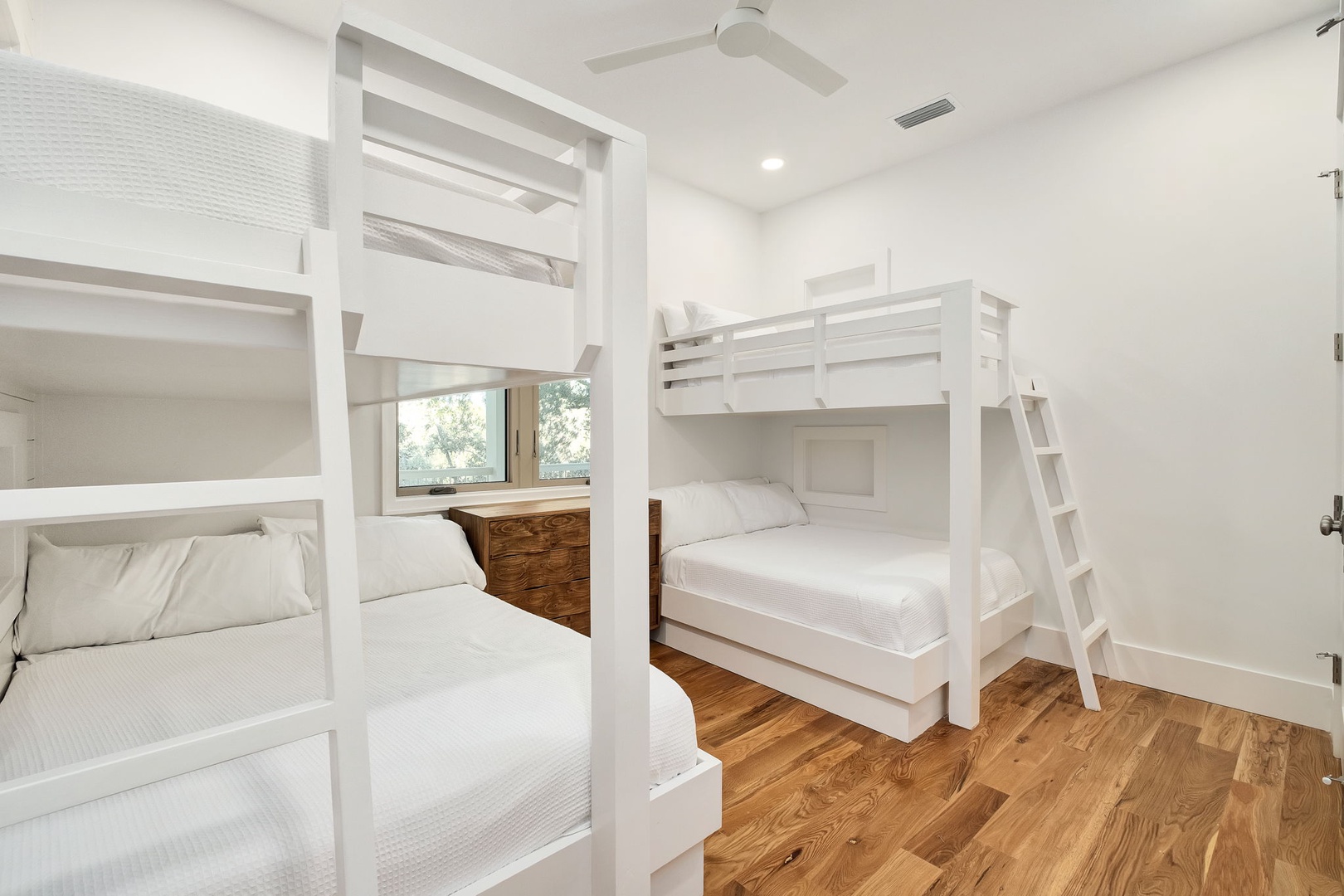 Your family will love this bright bunk room featuring custom white bunks with crisp linens, perfect for creating lasting memories together.