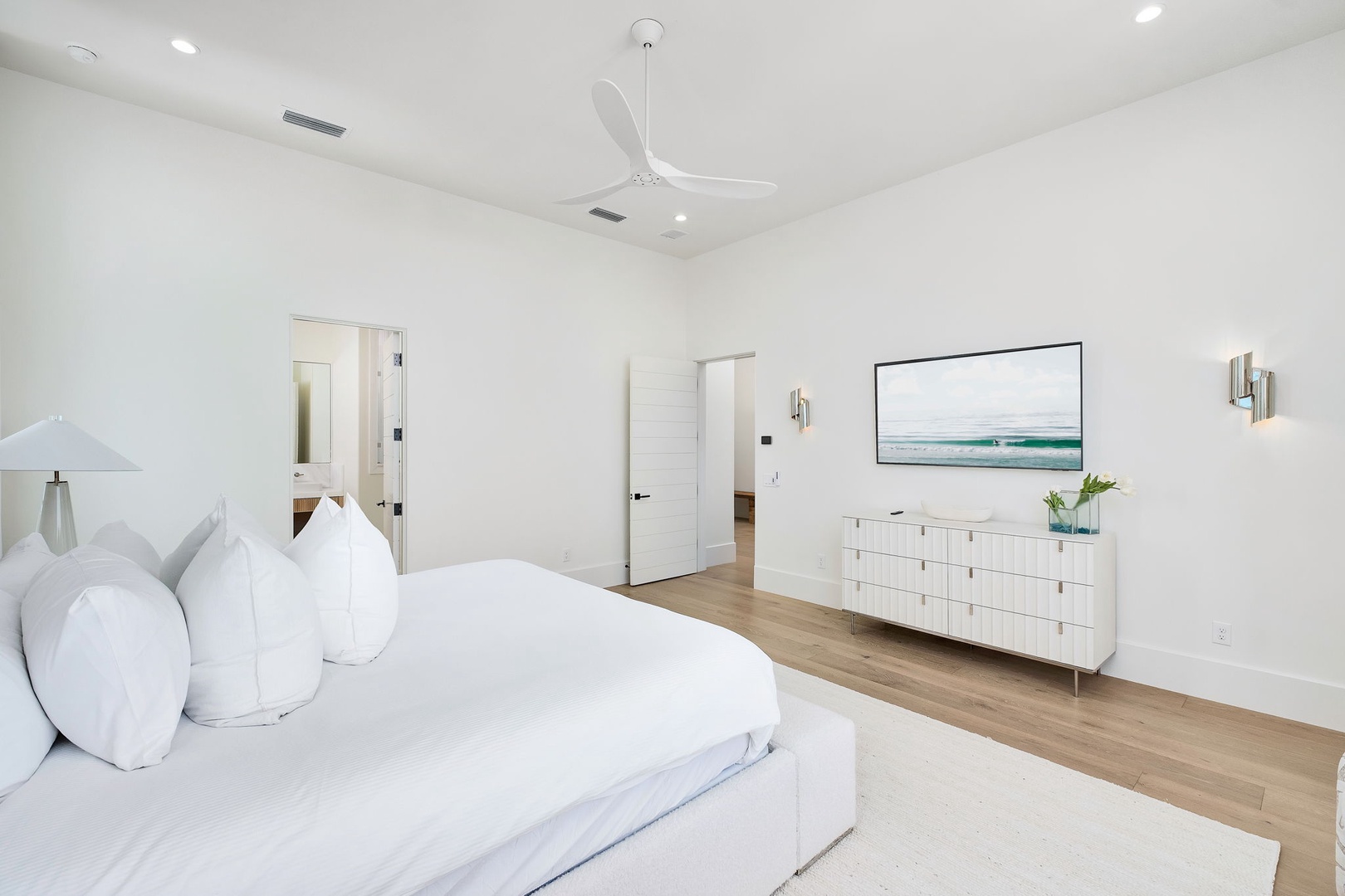 Sink into cloud-like comfort in this serene coastal bedroom. Crisp white linens and soft pillows await your arrival, while natural light and gentle breezes keep the space bright and airy.