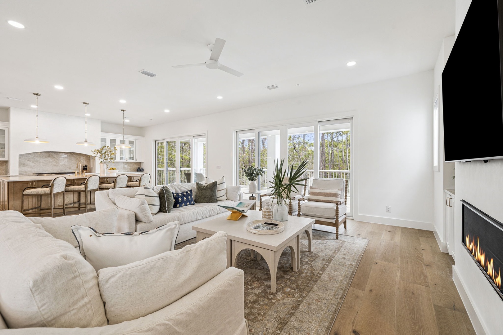 Sink into plush sofas in your bright, airy living space where a cozy fireplace and stunning tree views create the perfect retreat.