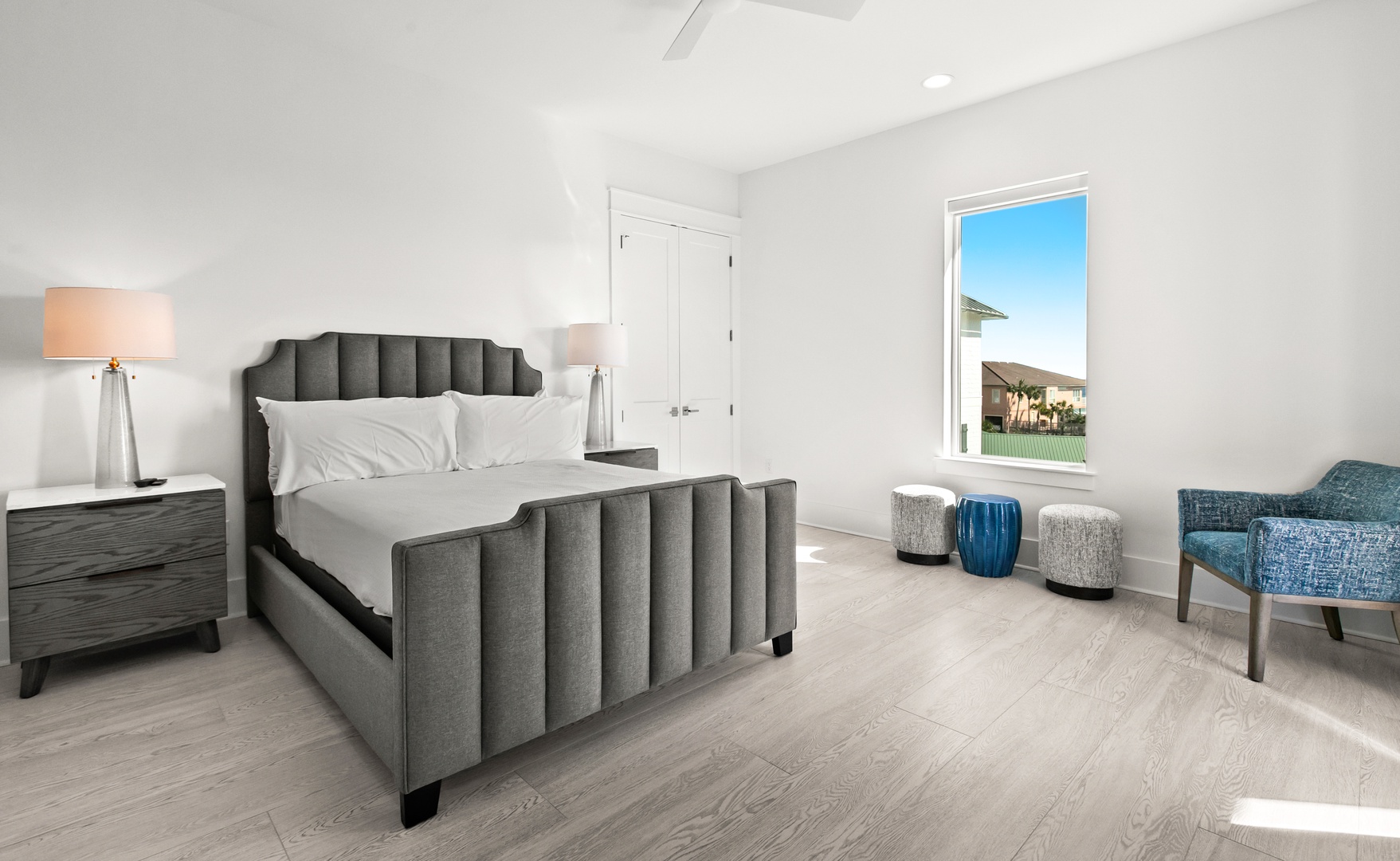 Unwind in your spacious bedroom, with a plush bed framed by soft lighting and a cozy reading chair by the window.