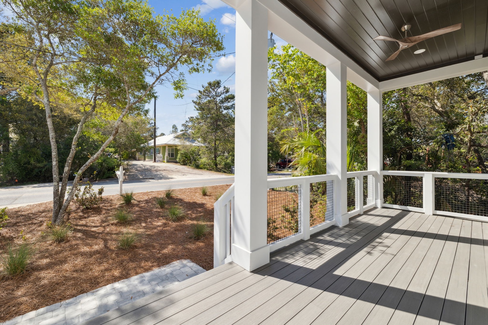 Relax on your private covered porch with ceiling fan, overlooking mature trees and peaceful surroundings in this tranquil retreat.