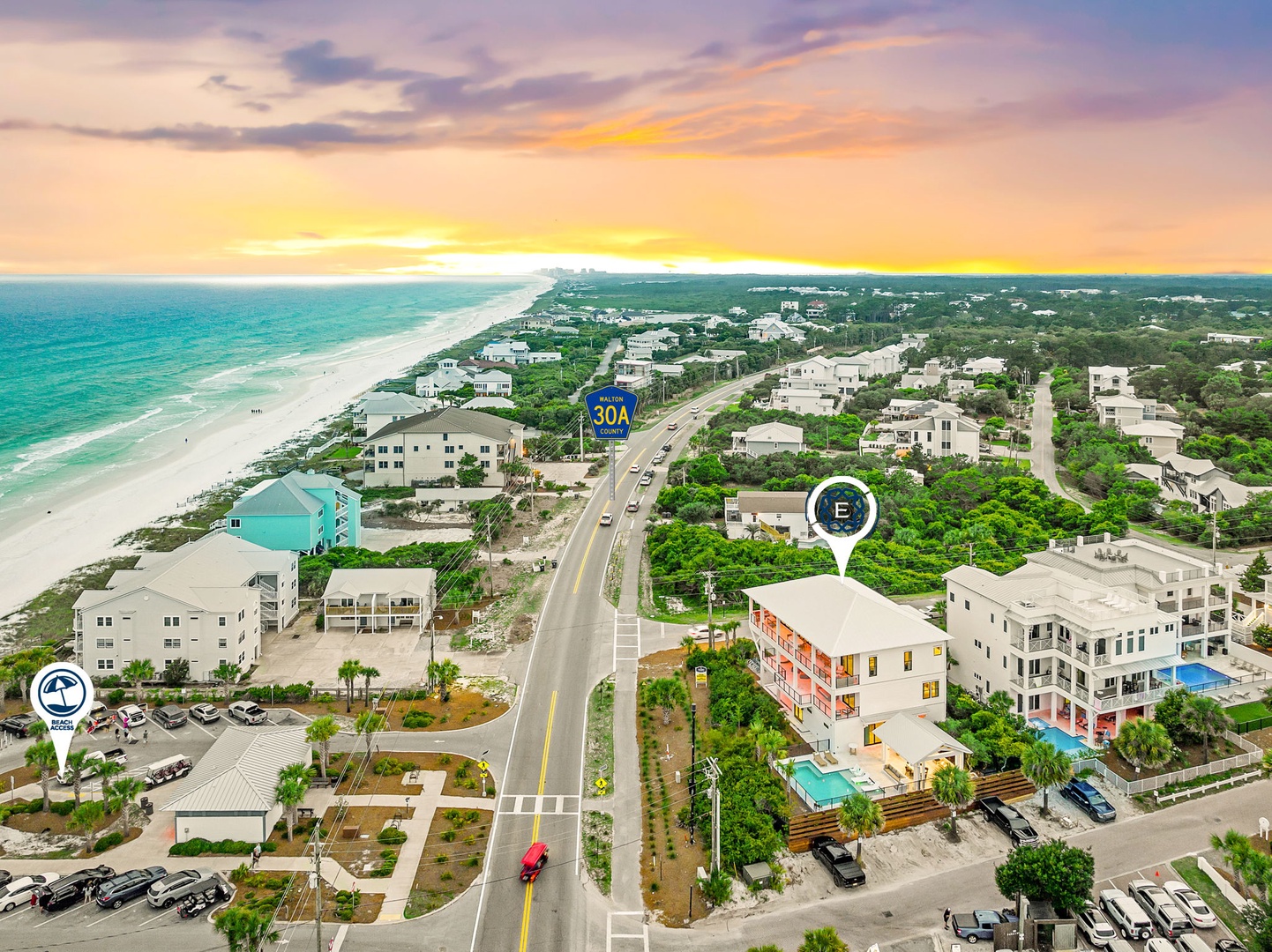 Aerial view of a charming beachside neighborhood with pristine turquoise waters, white sand beaches, and convenient access to local amenities along scenic coastal roads.