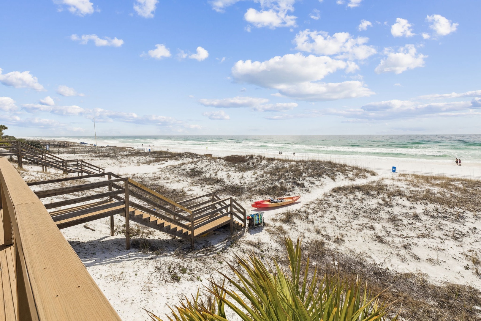 Pristine beach access with wooden boardwalk leading to white sand shores and emerald waters.