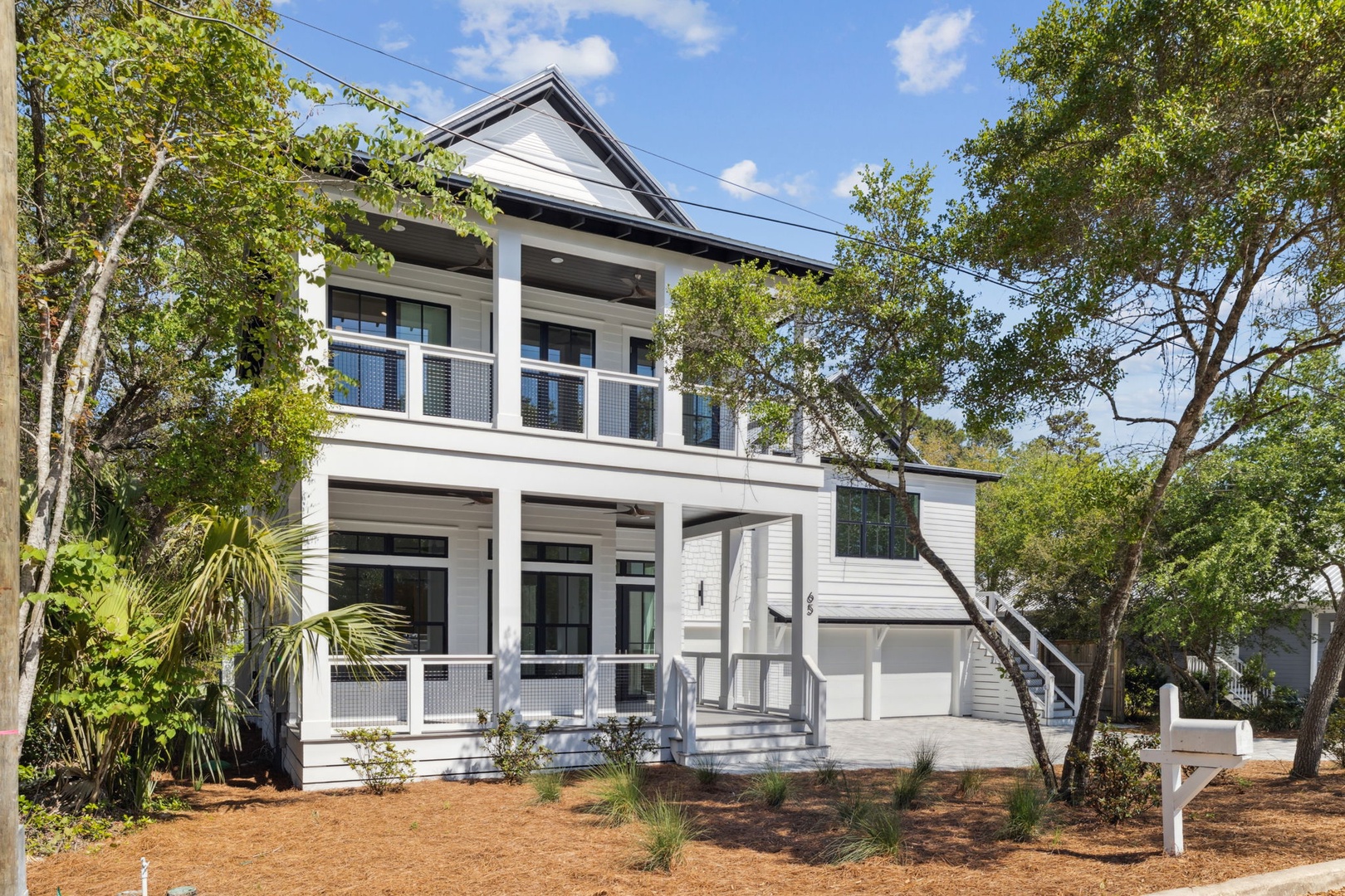 Modern coastal home nestled among mature trees in a peaceful residential setting.