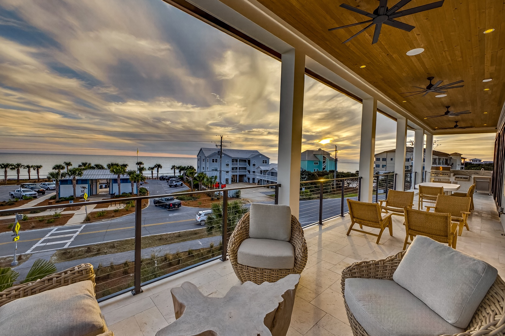 Unwind on your private covered terrace with comfortable wicker seating, ceiling fans, and stunning ocean views as golden hour paints the sky.