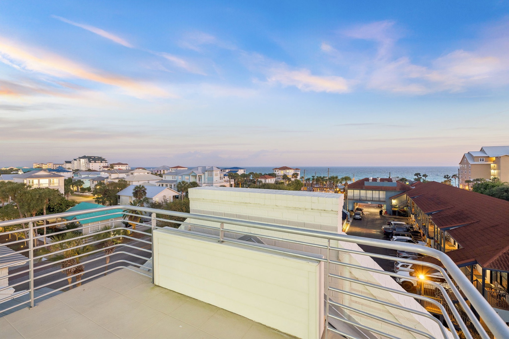 Elevated oceanfront terrace offers stunning views of the coastal community and sea beyond at twilight.