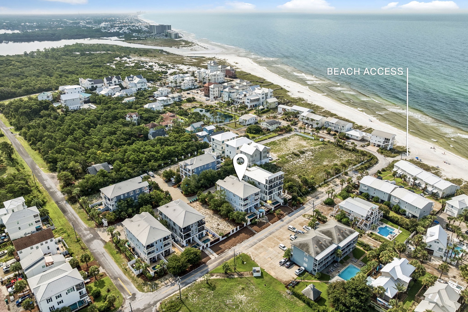 Aerial perspective of a coastal neighborhood with direct beach access, showcasing the property's prime location just steps from pristine white sands and the sparkling Gulf waters.