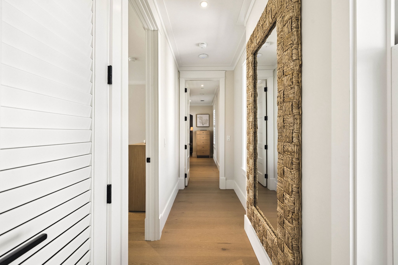 Bright hallways and coastal-inspired design elements guide you through this welcoming space, where clean lines and warm wood floors create an inviting flow between rooms.